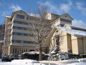 ein großes Gebäude mit einem Baum im Schnee in der Unterkunft Aeria Tohno - Vacation STAY 62233v in Tōno