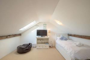 una camera mansardata con letto e TV di Large pretty holiday cottage by the sea sleeps 10 a Heacham