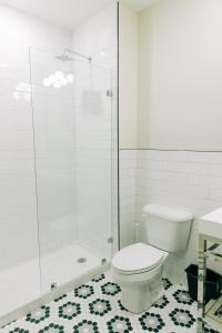 a white bathroom with a toilet and a shower at The St. Clair in Frankfort