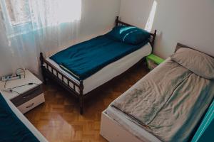 a small bedroom with two beds and a window at Apartment Benjo in Sarajevo