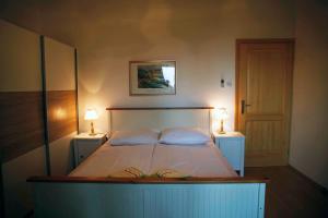 - une chambre avec un grand lit et deux lampes dans l'établissement Apartements Magdalena, à Lopar