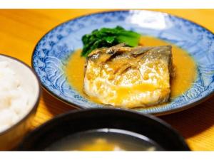 un plato azul de comida con carne y brócoli en una mesa en Shonan Relief - Vacation STAY 50853v, en Yokosuka