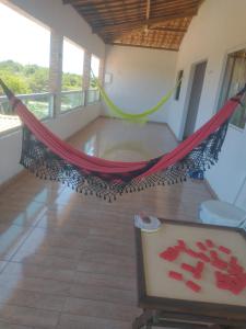 a hammock in the middle of a room at Cantinho da paz jesus nazareno in Gamela