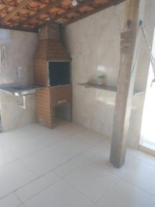 eine Küche mit einem Backsteinofen in einem Zimmer in der Unterkunft Cantinho da paz jesus nazareno in Gamela