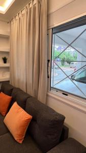 ein Sofa in einem Zimmer mit Fenster in der Unterkunft FlatG 23 in Athen