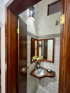 y baño con lavabo y espejo. en Casa térrea de, en São Sebastião