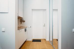 a kitchen with white cabinets and a door at Stylish Central Apartment - 5 mins to Old Town in Riga