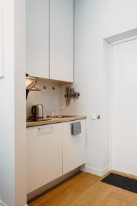 a kitchen with white cabinets and a sink at Stylish Central Apartment - 5 mins to Old Town in Riga