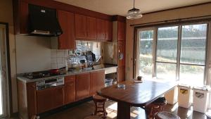 a kitchen with wooden cabinets and a wooden table with a wooden table sidx sidx sidx at Lilac Hotels and Resorts - Vacation STAY 53215v in Kanoya