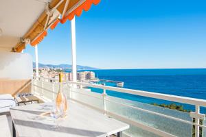 een tafel op een balkon met uitzicht op de oceaan bij Close to Monaco - Amazing Bay View - Free Parking in Saint-Antoine