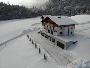 a building in the snow with trees in front of it at Apartment Tanzberger in Faistenau