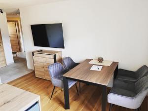 a room with a table and chairs and a flat screen tv at Apartment Tanzberger in Faistenau