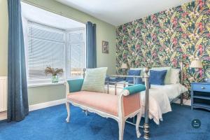 a bedroom with a bed and a chair and a window at Home AWey - Holiday home near harbour in Weymouth