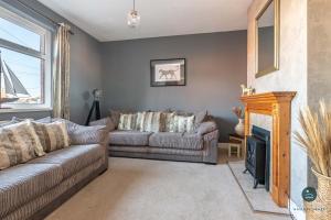 a living room with a couch and a fireplace at Home & A'Wey - Holiday home near harbour in Weymouth