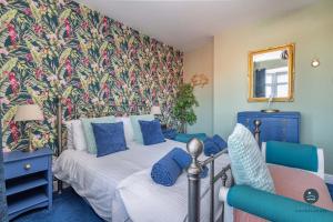 a bedroom with two beds and a floral wall at Home & A'Wey - Holiday home near harbour in Weymouth