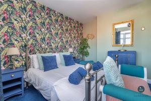 a bedroom with two beds and a floral wall at Home AWey - Holiday home near harbour in Weymouth