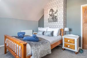 a bedroom with a bed with a wooden bed frame at Home AWey - Holiday home near harbour in Weymouth +11 photos