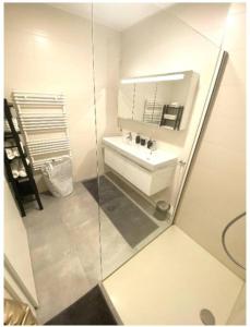 a white bathroom with a sink and a mirror at Luxury 2 bedrooms family flat in center w. Parking in Luxembourg