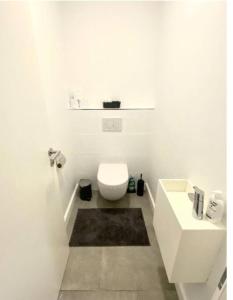 La salle de bains blanche est pourvue de toilettes et d'un lavabo. dans l'établissement Luxury 2 bedrooms family flat in center w. Parking, à Luxembourg
