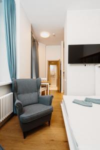 a bedroom with a chair and a bed at Stylish Central Apartment - 5 mins to Old Town in Rīga