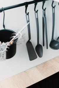 a row of black kitchen utensils hanging from a wall at Stylish Central Apartment - 5 mins to Old Town in Riga