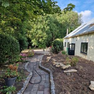 un jardín con un camino de piedra junto a una casa en Huize Dijkwater, en Dreischor