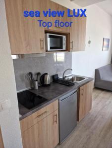 a small kitchen with a sink and a microwave at BLUE EYES APARTMENTS in Ixia