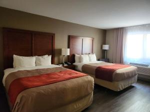 ein Hotelzimmer mit 2 Betten und einem Fenster in der Unterkunft Comfort Inn in Saint-Georges