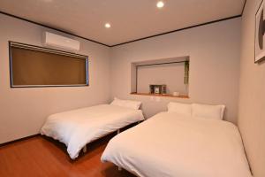 two beds in a small room with a window at Betteiyasu - Vacation STAY 16053 in Beppu