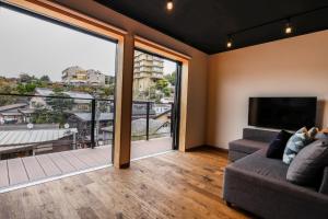 ein Wohnzimmer mit einem Sofa und einem großen Fenster in der Unterkunft Fu - Vacation STAY 57381v in Kōbe