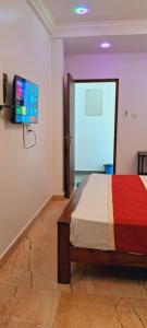 um quarto com uma cama e uma televisão de ecrã plano em Hill view resort em Kallana