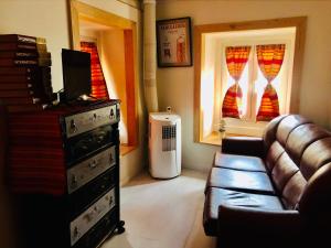 a living room with a couch and two windows at Casinhas da Calçada de Santiago - pet friendly, garage and with stairs in Tomar