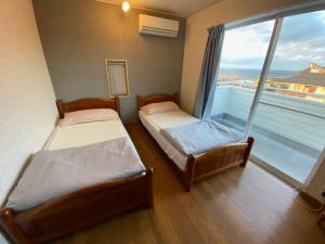 下関市にあるwhite house - Vacation STAY 60636vの大きな窓付きの客室で、ベッド2台が備わります。