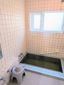 a tiled bathroom with a tub and a toilet at cheer house - Vacation STAY 59869v in Shikyū