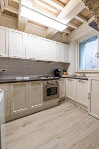 a kitchen with white cabinets and a stove top oven at Casa Tarducci in Urbania +27 photos
