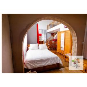 Un dormitorio con un arco y una cama. en Villa Fialofana Ambohimarina, 