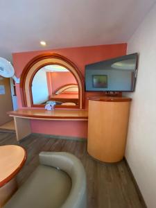 ein Bad mit einem TV und einer Badewanne in einem Zimmer in der Unterkunft Hotel Gran Vía in Mexiko-Stadt