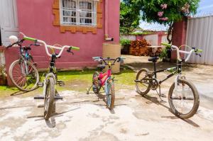 にあるVilla Fialofana Ambohimarinaのピンクの家の前に駐輪した自転車3台