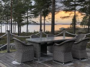 a table and chairs on a deck with a view of the water at Havsnära villa in Nordmaling