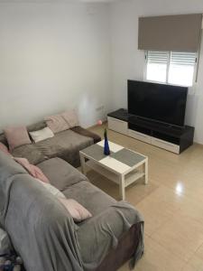 sala de estar con 2 sofás y TV de pantalla plana en Pericos Gilet, en Gilet
