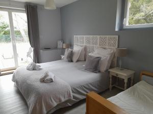 um quarto com 2 camas com lençóis brancos e uma janela em L'AMANDAURE em Saulcy-sur-Meurthe