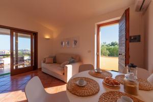 uma sala de estar com um sofá e uma mesa em Appartamento Figari em Golfo Aranci