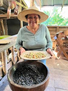 Una donna con un cappello di paglia che tiene un piatto di cibo di Eco Horqueta a Boquete