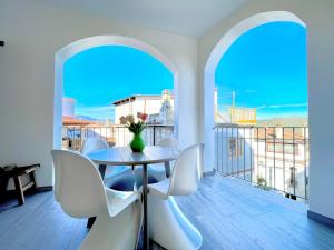 a table and chairs in a room with a balcony at Le Corti Sarde Apartments in Bari Sardo