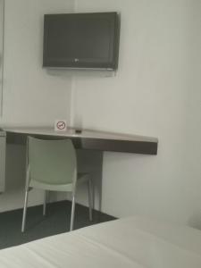 a desk with a chair and a television on a wall at SUN1 Vereeniging in Vereeniging