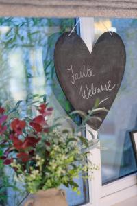 a heart sign on a door with a bouquet of flowers at Mary's Lane in Randalstown