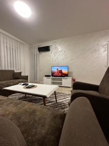 een woonkamer met 2 banken en een tv bij Lovely Family Apartment in Ferizaj