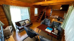 a living room with couches and a table in a cabin at Asahikawa City - Camp - Vacation STAY 62748v in Chikabumichō