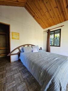 Bett in einem Schlafzimmer mit Holzdecke in der Unterkunft Eco Horqueta in Boquete