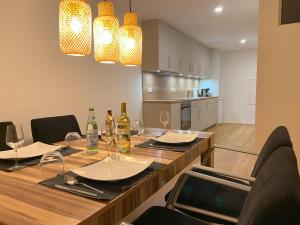 a dining room table with chairs and wine bottles at Business & Relax Wohnung direkt im Stadtkern Oettingens in Oettingen in Bayern